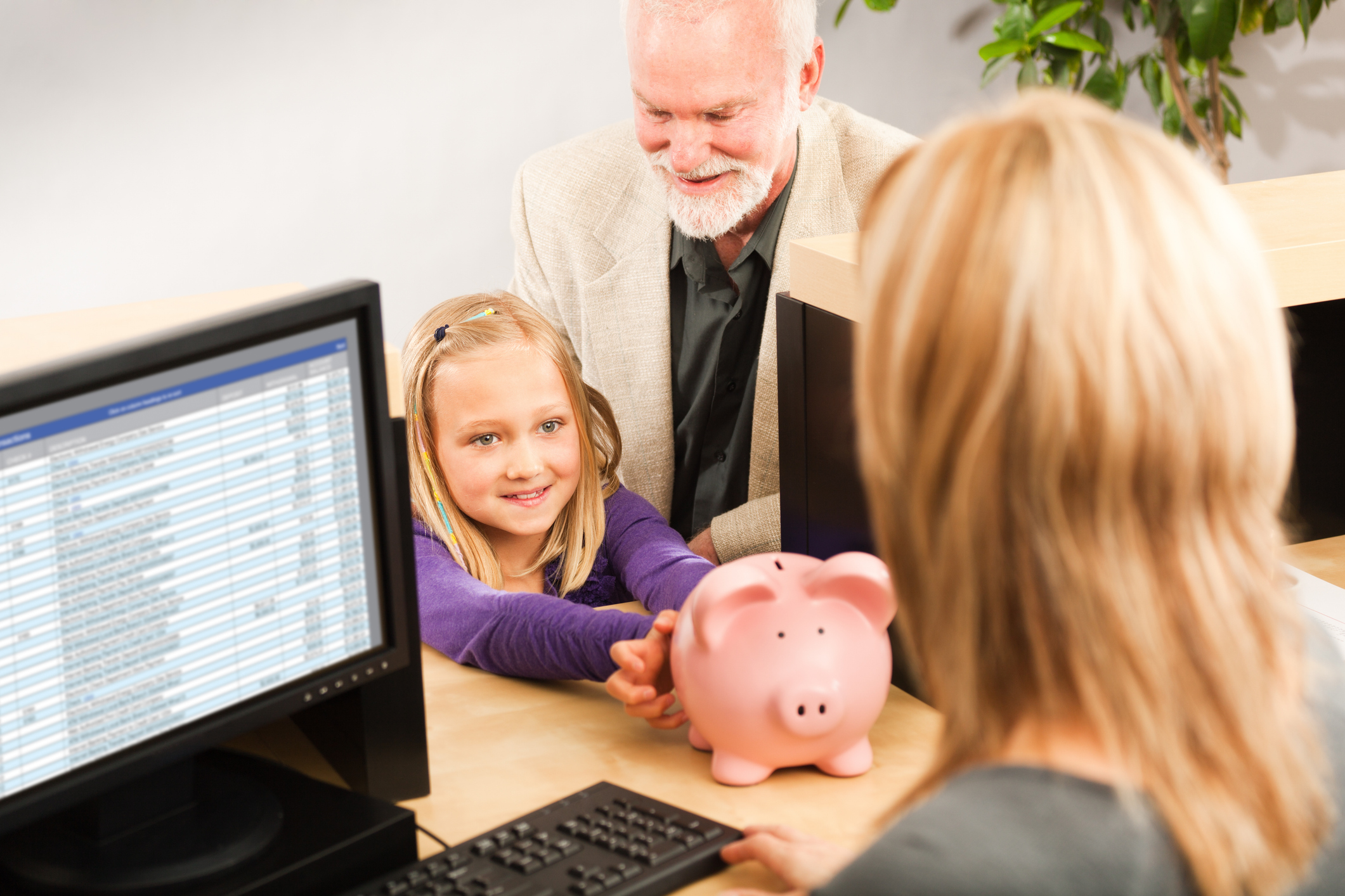 Child With Grandfather Handing Piggybank To Financial Advisor | Zinner & Co. CPAs and Consultants